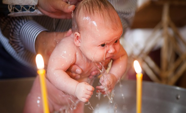 На фото – крещение малыша в купели